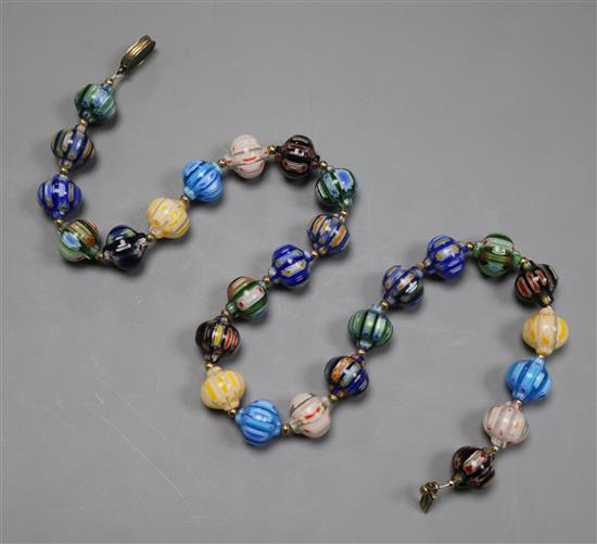 An early 20th century Venetian? cane glass bead necklace, with yellow metal spacers and clasp inscribed 1910, 47cm.